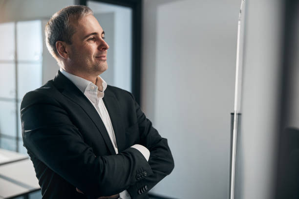 istock Joyful businessman standing by whiteboard in office 1313347193