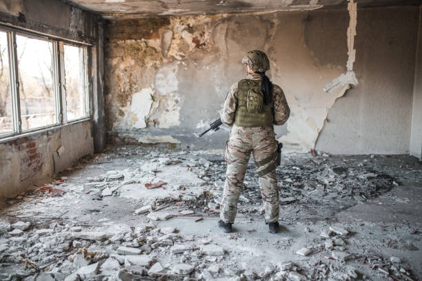 istock Armed female soldier in camouflage uniform in war zone 1313348010
