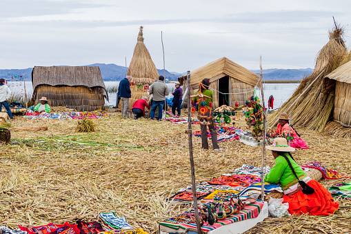 TITICACA, PERU - MAY 15, 2015: Tourists visit Uros floating islands, Titicaca lake, Peru