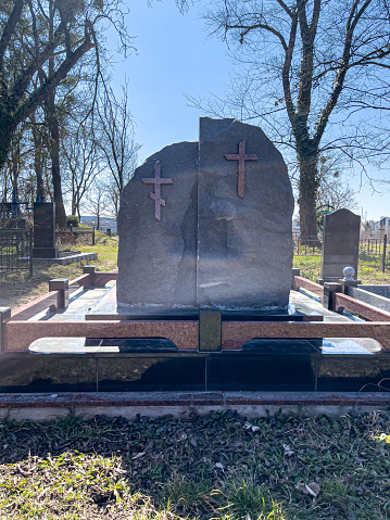 Two graves with crosses in the cemetery on a sunny day.