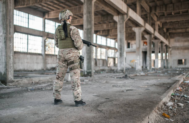istock Professional woman soldier with weapons in war zone 1313349526