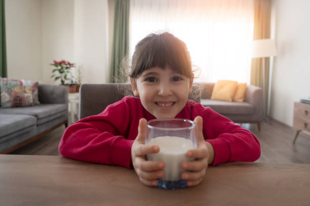 istock Cute little child drinking milk on table 1313350587