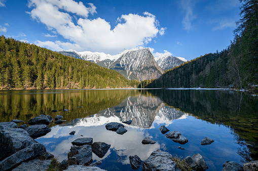 Beautiful reflection from the mountains, the forests and the clouds at Piburg lake in Austria