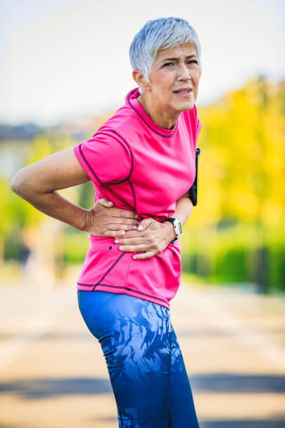istock Woman getting injured while training outdoors. Athletic woman having backpain 1313351438