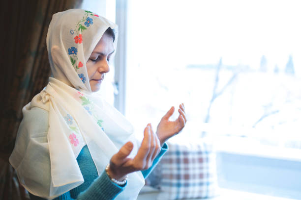 istock muslim woman, headscarf, hands open praying 1313353180