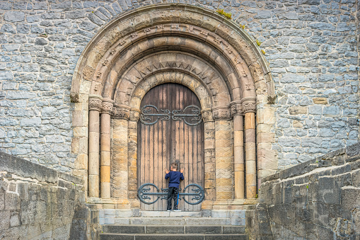 Boy peeps through keyhole into Saint Mary's Cathedral in downtown Limerick, Ireland. It was founded in 1168 and is the oldest building in Limerick which is in use.