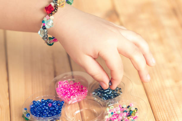 istock The child makes jewelry with his own hands, stringing colorful beads on a thread 1313356749