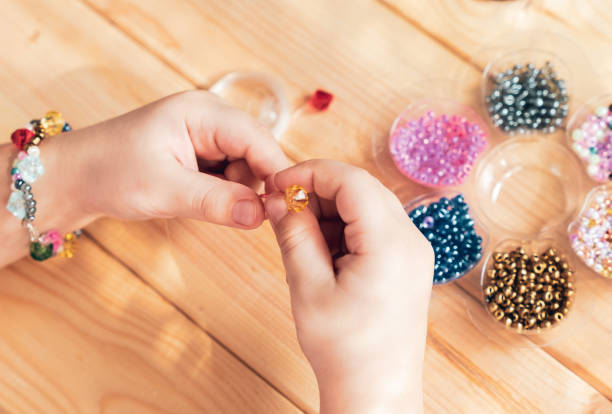 istock The child makes jewelry with his own hands, stringing colorful beads on a thread 1313356751