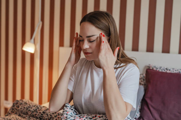istock Young woman has a headache in bed 1313356889