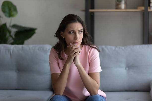 istock Doubtful arab female sitting on couch lost in serious thoughts 1313357885