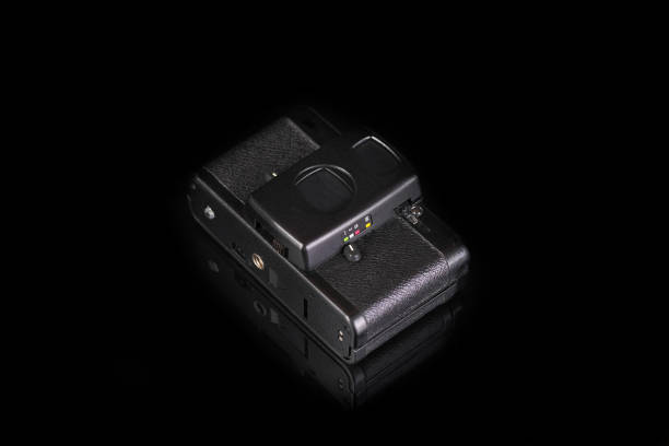 istock The old very popular automatic film camera on black glass background with reflection. 1313360260
