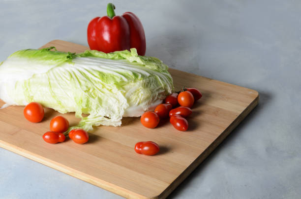 まな板の上の野菜。ボード�上の赤ピーマン、トマト、ペトセシキャベツ - タケノコ白菜 ストックフォトと画像