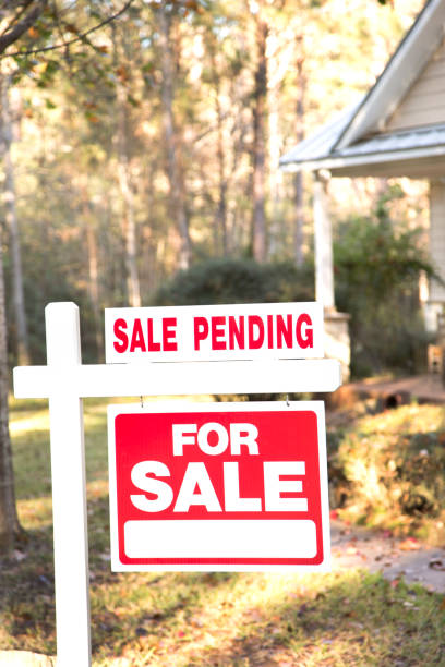 Home for sale with real estate sign.  Front Yard. Home for sale with red and white real estate sign during the fall season.  Fall season with leaves on ground.  Front porch and windows in background.  Residential neighborhood.  Moving house, relocation concept. Sale Pending. real estate outdoors vertical usa stock pictures, royalty-free photos & images