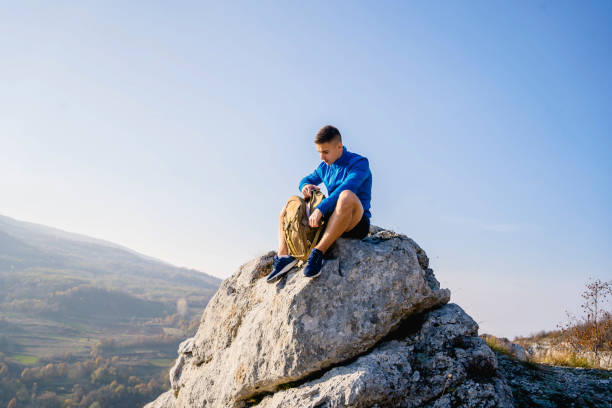 istock Mountaineer relaxing on mountain ridge 1313373358