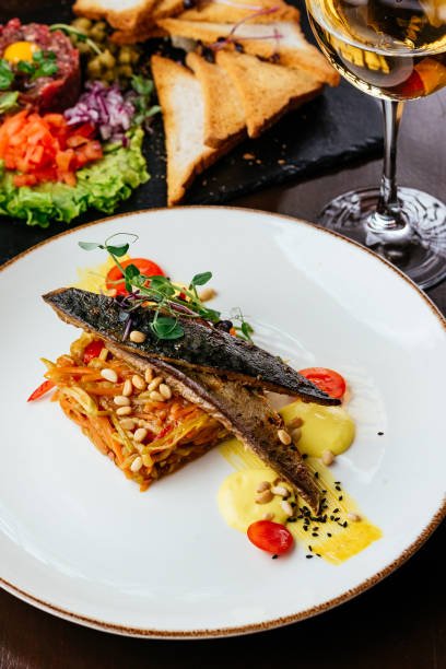 istock grilled fish in a plate with vegetables and sauce 1313373606