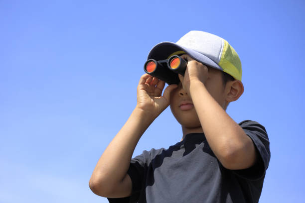 istock Japanese boy with opera glass under the blue sky (10 years old) 1313375269