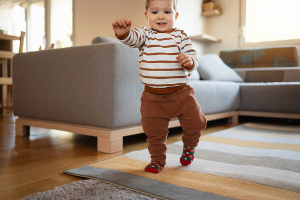 istock Happy baby boy making his first steps at home 1313379406