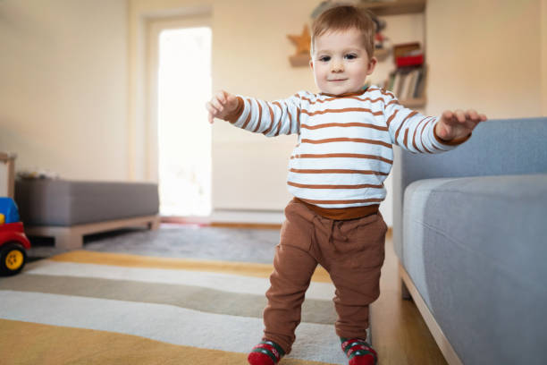istock Happy Caucasian baby boy making his first steps at home 1313379413