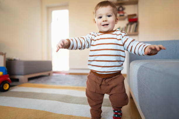 istock Adorable Caucasian baby boy making his first steps at home 1313379416