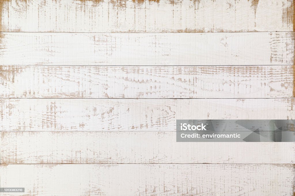 Old weathered abstract white-colored paneled oak wood background with lots of wood grain and texture. Old-fashioned worn white wooden paneling with patches of wood showing through the white paint. Nice rustic feel suitable for a classic background or for copy space. Wood - Material Stock Photo