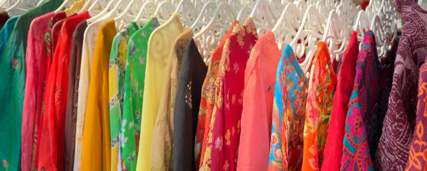 istock Multi-colored abstract patterned garments hanging from a clothes rack in an outside Asian market. 1313383213