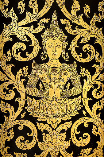 Thai Buddhist temple floral motif on an old antique wooden door at an old Thai Buddhist temple.