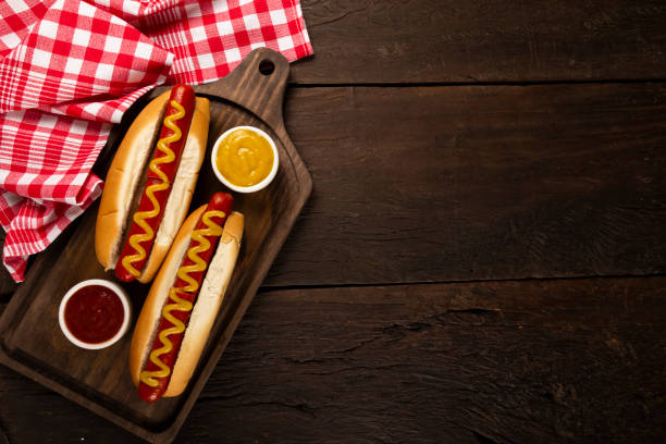 hot dog with ketchup and yellow mustard. - hot dog imagens e fotografias de stock