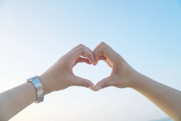 istock Close-up, heart shape with hands under the sky 1313388138
