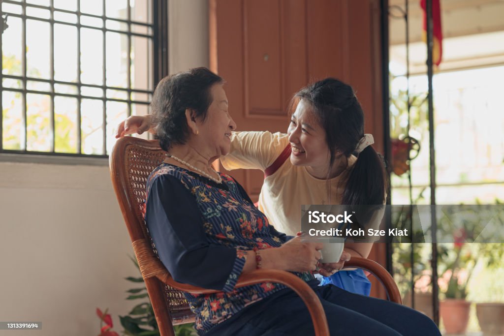 Asian granddaughter visiting her grandmother Community Outreach Stock Photo