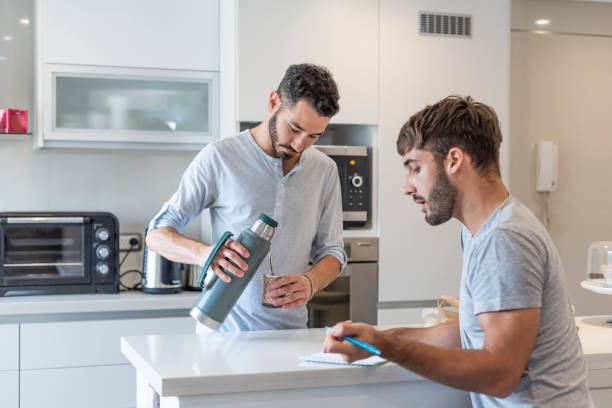istock Young man writing in a paper while his boyfriend is preparing mate infusion 1313392329