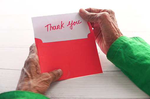 senior women's hand holding thank you letter , rear view ,