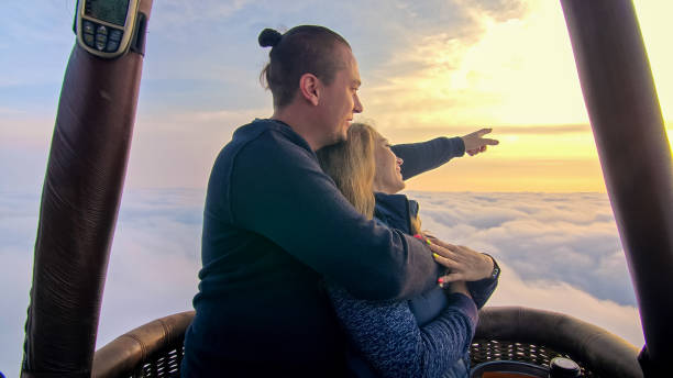 couples d’amour d’aventure sur la pastèque de montgolfière. l’étreinte d’embrasse d’homme et de femme s’aiment. brûleur ant la flamme dans l’enveloppe. des gens heureux. - hot air balloon flying heat people photos et images de collection