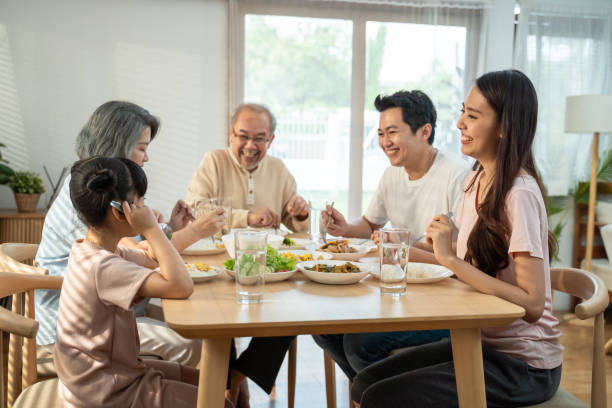 큰 아시아 행복 가족은 함께 저녁 식사 테이블에 점심을 먹고 시간을 보낸다. 어린 아이 딸은 아버지, 어머니, 조부모와 함께 음식을 먹는 것을 즐깁니다. 다세대 관계 및 활동 - family dining table breakfast eating 뉴스 사진 이미지