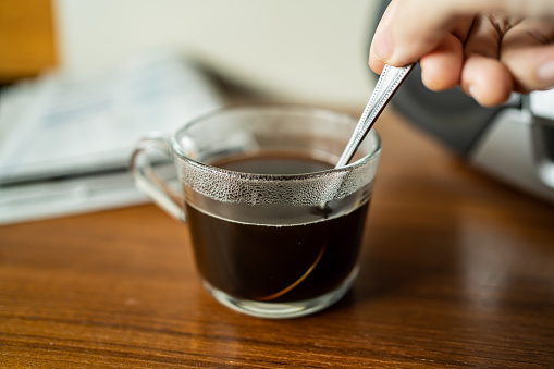Revolviendo café en una taza con cucharadita photo