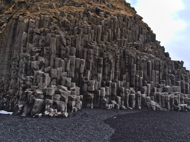 View of basaltic rock formations on famous beach Reynisfjara with black pebble stones on the southern coast of Iceland. stock photo