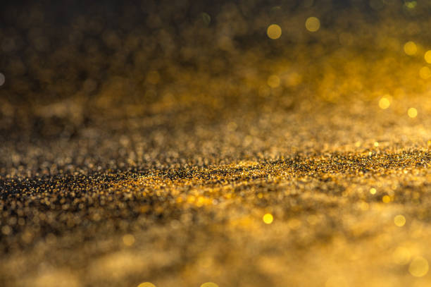 istock Gold glitter texture on black background. Sparkling gold bright bokeh from blurred diamond dust. Abstract golden bokeh background. Selective focused 1313404836