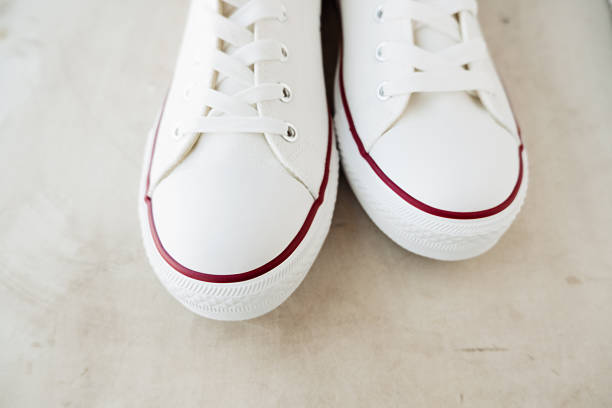 istock white new clean sneakers with white laces on a rubber sole on a gray background. selective focus 1313408050