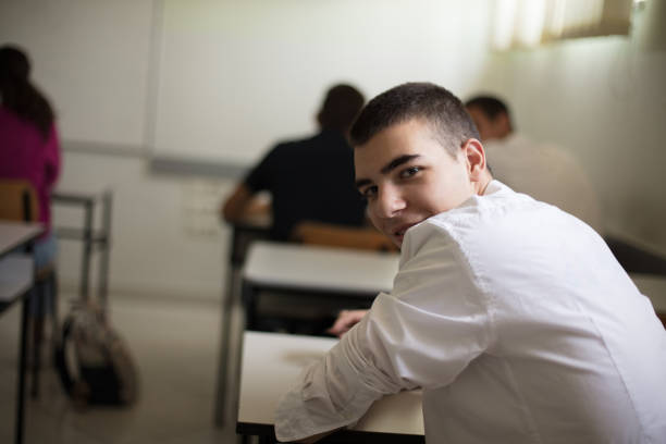 istock School is back.  Teenage student sitting in a classroom. Looking at camera. 1313408996