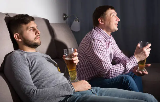 Photo of Indifferent gu with friend emotionally watching tv