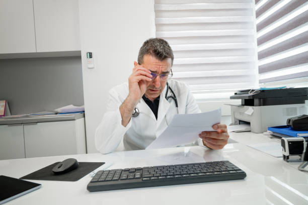istock Doctor reading test results at his desk, looking shocked 1313410614