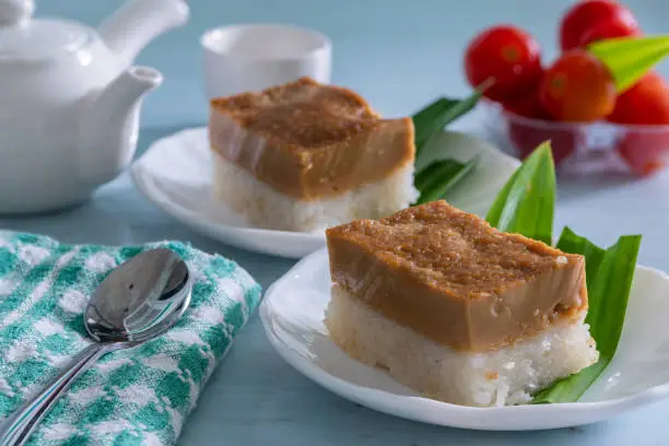 Pulut Sekaya, a Glutinous Sticky Rice Cake with Palm Sugar topping, two pieces on a white plate each.