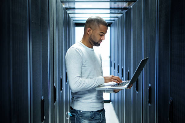 un tecnico di sala server maschio nero che lavora alla riapertura aziendale - data center network server computer network foto e immagini stock