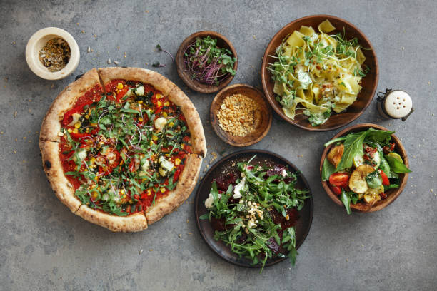 Vegetarian dishes Vegetarian Pappardelle with zucchini and eggplant. Fresh vegetable salad with sun dried tomato, spinach and potato chips. Vegan roasted beetroot salad with arugula, tofu and nuts. Vegetarian pizza with tomato sauce, cauliflower, corn, arugula, nuts and microgreen. Flat lay top-down composition on concrete background. vegan stock pictures, royalty-free photos & images