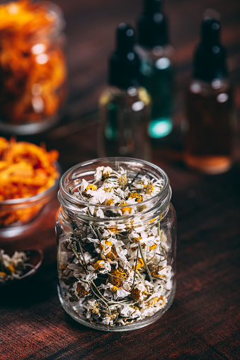 Dried Flowers and Bottles of Essential Oil on the Rustic Wooden Table