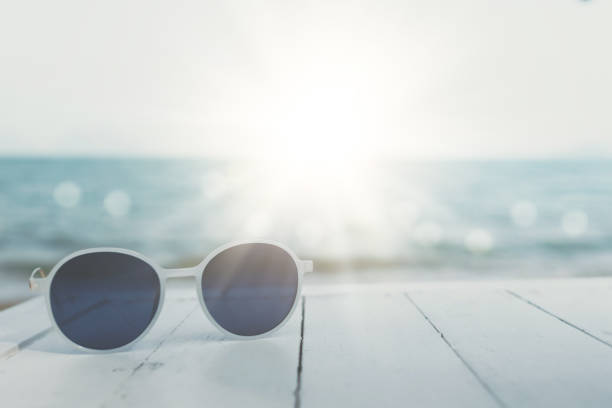 istock Selective focus of sunglasses on the table at summer beach resort with sunlight background. Holiday vacation travel tourism concept. 1313419969