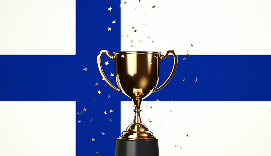 Star shaped gold confetti falling onto a gold cup sitting over  Finnish flag background. Horizontal composition with copy space. Front view. Championship concept.