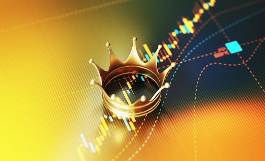 Gold crown sitting on yellow financial graph background. Horizontal composition with selective focus and copy space. Investment, stock market data and finance concept.