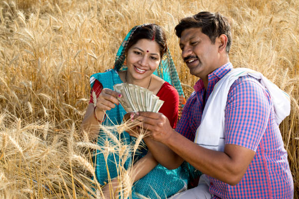 Rural couple holding Indian rupee notes in agriculture field Rural farming couple holding Indian rupee notes in agriculture field the farmer and his wife pictures stock pictures, royalty-free photos & images