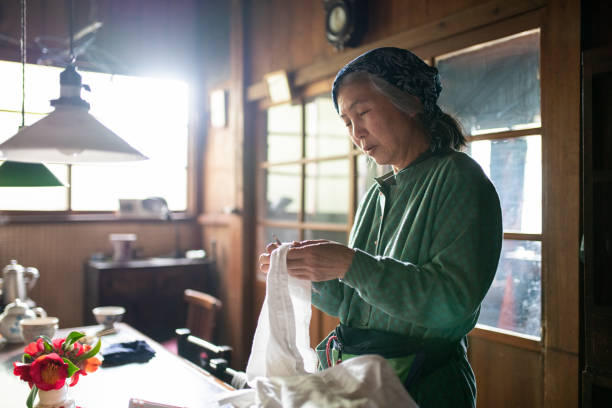 istock Senior woman sewing at home 1313421622