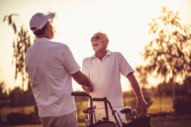 istock Two seniors golfers men talking on golf court. 1313422843